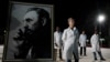 Médicos cubanos posan al lado de un cuadro del fallecido dictador Fidel Castro. (Foto: REUTERS/Alexandre Meneghini, Archivo)