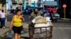 Un hombre empuja una carretilla con sacos de alimentos por una calle de La Habana. (Yamil Lage/AFP)