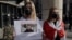 Una mujer sostiene un cartel durante una protesta en contra del arresto del bloguero bielorruso, Roman Protasevich