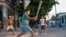Niños cubanos en un improvisado juego callejero de béisbol.