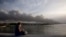 Una mujer contempla desde el malecón el humo del incendio en la Base de Supertanqueros de crudo en la Bahía de Matanzas, este martes, 9 de agosto. (AP Foto/Ismael Francisco)