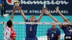 Jugadores rusos intentan bloquear un remate de Dennis en un partido contra el equipo italiano Macerata.