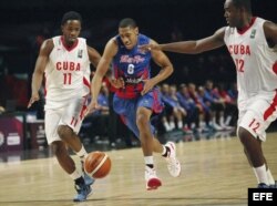 Richard Chanel (c) de Puerto Rico disputa el balón contra dos jugadores cubanos.