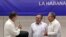 El líder de las FARC, Rodrigo Londoño Echeverri, alias "Timochenko" (c), habla con los presidentes de Cuba, Raúl Castro (d), y de Colombia, Juan Manuel Santos (i), en La Habana.