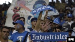 Varios aficionados del equipo de Industriales animan a su equipo.