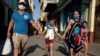 Una familia cubana con protección en medio de la pandemia, en marzo de 2020. (REUTERS/Alexandre Meneghini).