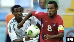 El futbolista cubano Olaitan Michail (d) lucha por el control del balón ante el nigeriano Yolexis Collado (i).