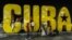 Niños juegan en una gran cartel de Cuba.