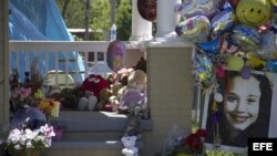 Detalle de muñecos y globos colocados por vecinos en la puerta de la casa de Gina DeJesús, una de las tres jóvenes que fueron liberadas el lunes en una vivienda en la Avenida Seymore de Cleveland.