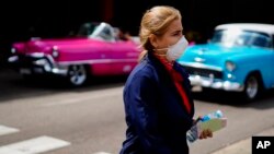 Una mujer usa una máscara como protección contra el coronavirus en La Habana.