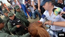 Juan Manuel Santos saluda a miembros de la Guardia Nacional Bolivariana en su visita a un paso fronterizo. EFE.