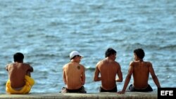 Varios jóvenes conversan en el Malecón habanero.