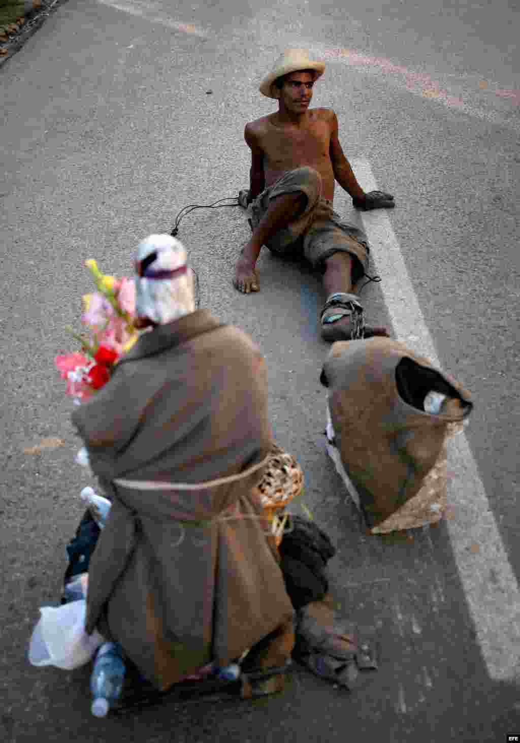  Un hombre toma un descanso mientras arrastra una piedra y una imagen de San Lázaro el domingo 16 de diciembre de 2012, durante una procesión en el Santuario de El Rincón, Cuba. 
