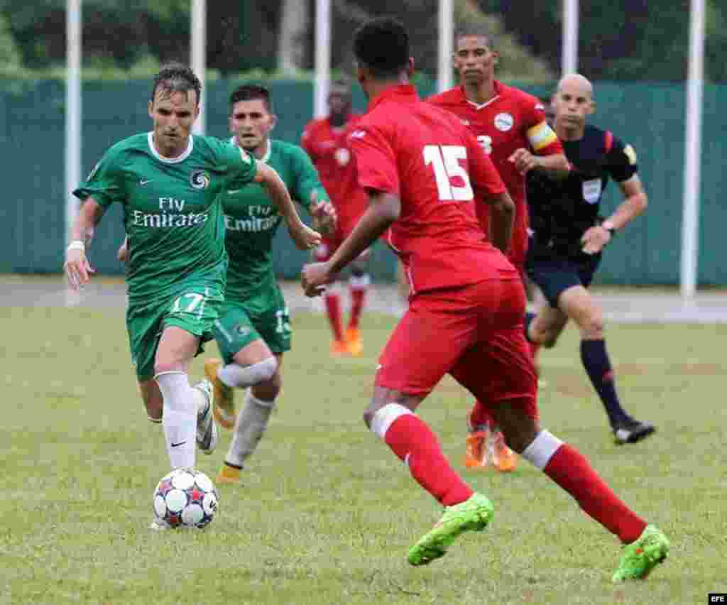Azoye García (i) del Cosmos de Nueva York conduce el balón ante jugadores de la selección nacional de Cuba.