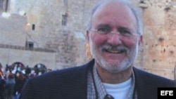 Una persona sostiene una pancarta en la que pide que sea liberado el contratista Alan Gross. 