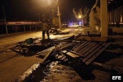 Un bombero pasa al lado de destrozos causados en Con Con, cerca de Valparaíso, por la penetración del mar que siguió al sismo,