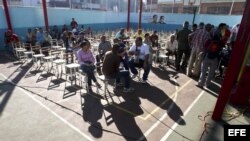 Ciudadanos venezolanos asisten a un centro de votación para participar en las elecciones regionales del 16 de diciembre del 2012, en Caracas 