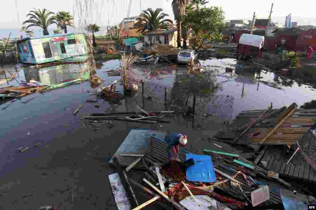 Una mujer camina entre los destrozos causados por el tsunami que siguió al terremoto en Chile.
