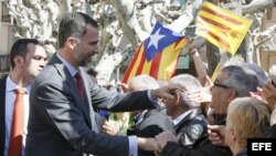 El rey de España, Felipe de Borbón, visita Cataluña, cuando todavía era Príncipe, en 2013. Detrás, banderas independentistas.