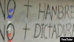 Reclamos sociales escritos en la fachada de una casa en Mella, Santiago de Cuba.