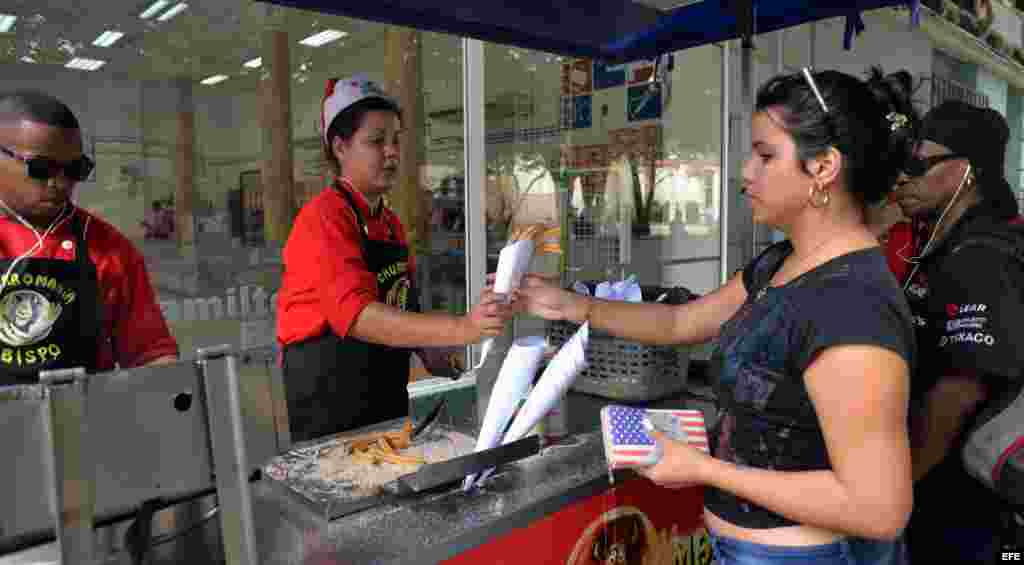 Una mujer vendiendo churros con un gorro navideño en La Habana. EFE