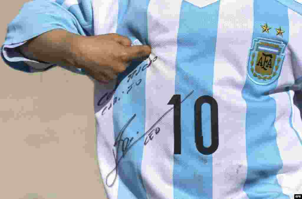 El niño afgano de 5 años, Murtaza Ahmadi, un joven seguidor del delantero argentino del FC Barcelona Lionel Messi, juega con una camiseta de la selección nacional argentina firmada por el astro argentino en Kabul (Afganistán).