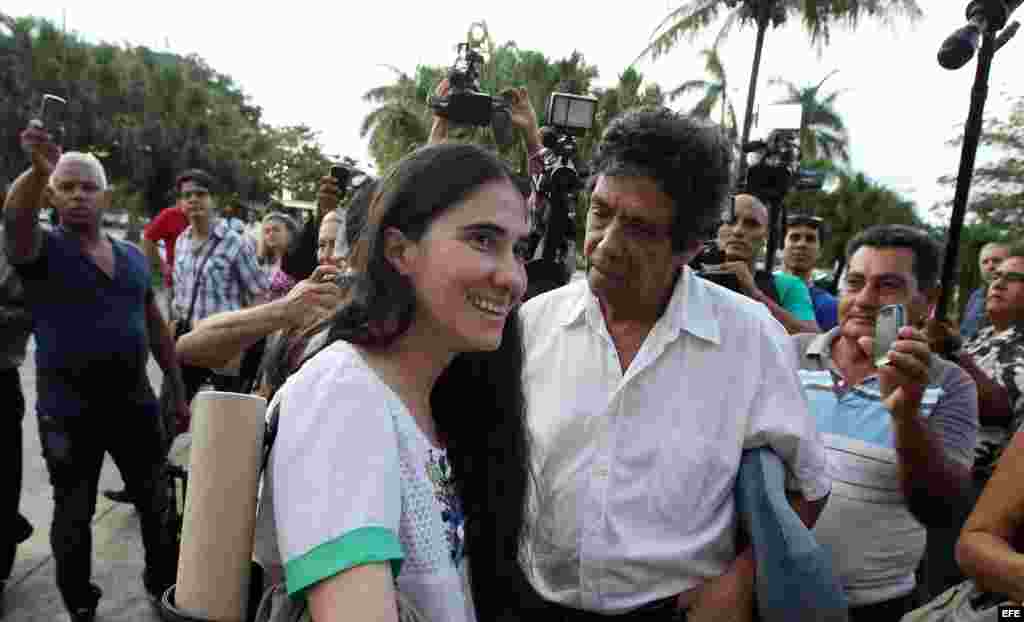 La bloguera cubana Yoani Sánchez (c), creadora del blog "Generación Y", habla con su esposo, el opositor Rainaldo Escobar (i), y su hijo, Teo (d), a su llegada a La Habana (Cuba) hoy, jueves 30 de mayo de 2013, luego de una gira de más de 100 días por var