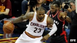 LeBron James (i) de Cleveland Cavaliers en acción ante DeMarre Carroll (d) de Toronto Raptors.