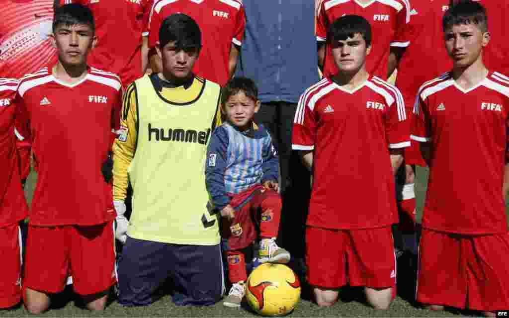 El niño afgano de 5 años Murtaza Ahmadi(c) posa con jugadores locales ataviado con una camiseta de su ídolo, el delantero argentino Lionel Messi, hecha con una bolsa de plástico, en un campo de fútbol de Kabul, Afganistán.
