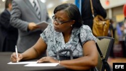 Una desempleada llena una solicitud de empleo.