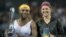 Serena Williams (i) y Victoria Azarenka (d) posan con sus trofeos.
