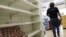 Un cliente recorre un pasillo con estanterías desabastecidas en un supermercado de Caracas (Venezuela).