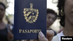 Una cubana muestra su pasaporte cubano obtenido en una oficina de Inmigración en La Habana, Cuba. 